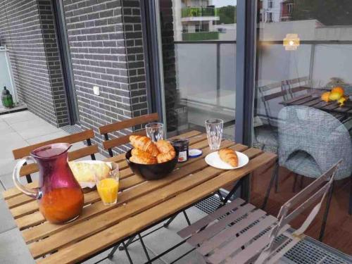- une table avec un bol de nourriture et un pichet de jus d'orange dans l'établissement Appartement 80m2, terrasse sud, metro 7 direction Louvre à 8minutes, parking sous-sol, proche Paris-Bercy, à Ivry-sur-Seine