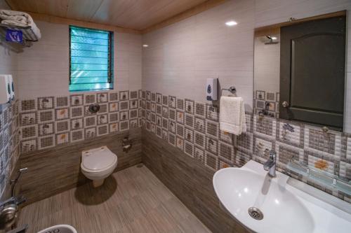 uma casa de banho com um WC e um lavatório em Silvanus Forest Retreat, Alibaug em Alibag