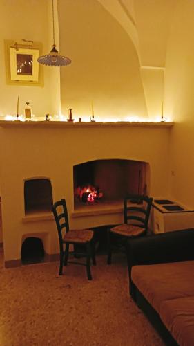 a living room with a fireplace and two chairs at Palazzo Ferilli Alfonso in Ruffano