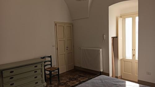 1 dormitorio con vestidor, silla y ventana en Palazzo Ferilli Alfonso, en Ruffano