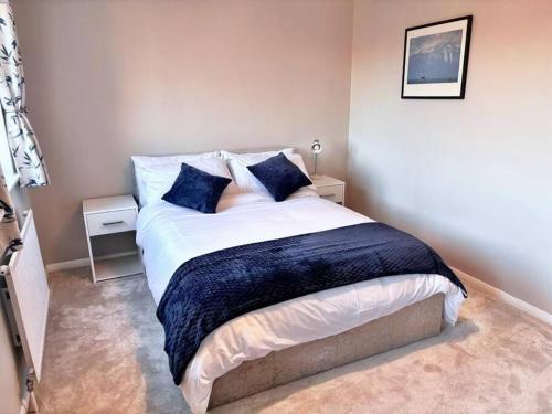a bedroom with a large bed with blue pillows at Apartment in Epsom With Free Parking in Epsom