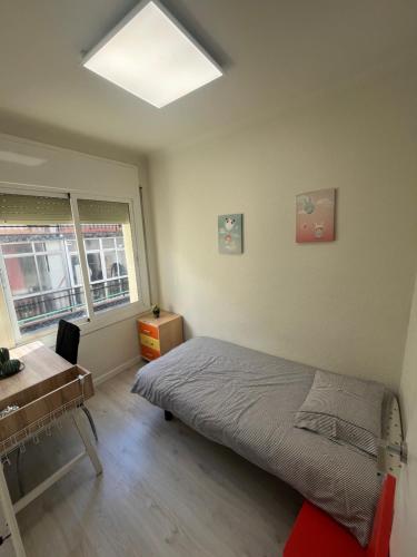 1 dormitorio con cama, escritorio y ventana en Precioso apartamento en Premià de Dalt, en Premià de Dalt