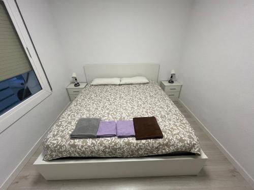 Un pequeño dormitorio con una cama con toallas. en Precioso apartamento en Premià de Dalt, en Premià de Dalt