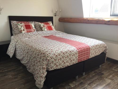 a bedroom with a bed with a red and white blanket at Holiday in Spakenburg Groof in Spakenburg