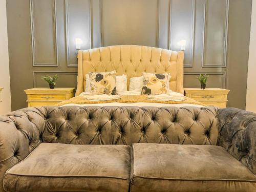 a bedroom with a bed with a leather couch at The Lux Guesthouse in Kroonstad