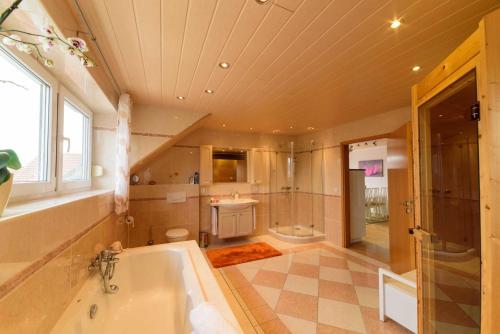 a bathroom with a tub and a shower and a sink at Ferienwohnung-Herbolzheim in Herbolzheim