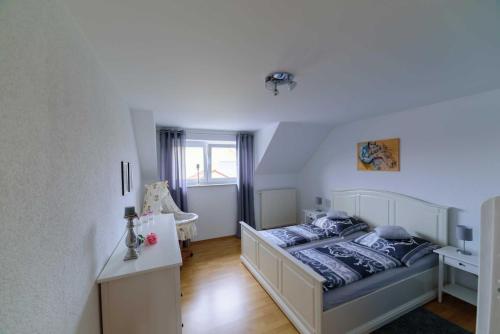 a bedroom with a bed and a desk in it at Ferienwohnung-Herbolzheim in Herbolzheim