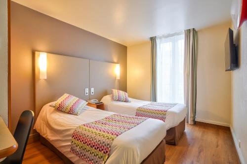 um quarto de hotel com duas camas e uma janela em Campanile Paris 14 - Maine Montparnasse em Paris