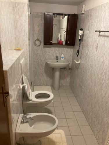 a bathroom with a toilet and a sink at Tchambre in Brusson