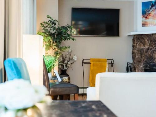 a living room with a table and chairs and a tv at Lovely 3-bedroom rental unit with free parking! in Anchorage