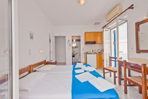 een slaapkamer met een groot bed met blauwe lakens bij Paris Rooms in Antiparos Stad