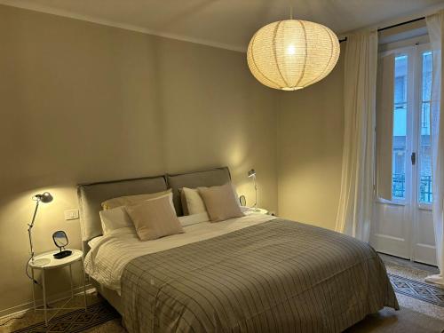 巴里的住宿－Casa di Leonardo Elegant & Comfort，一间卧室配有一张大床和一个吊灯。