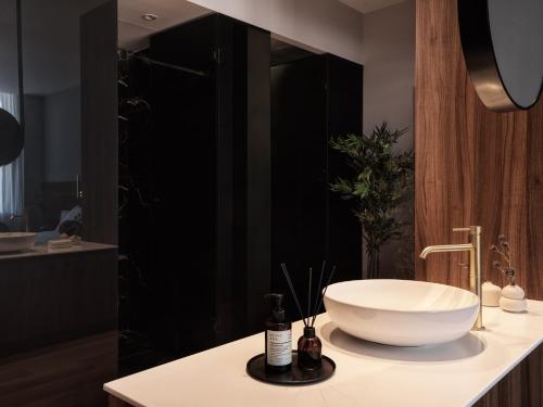 a bathroom with a white bowl sink on a counter at The Newel Acropolis in Athens