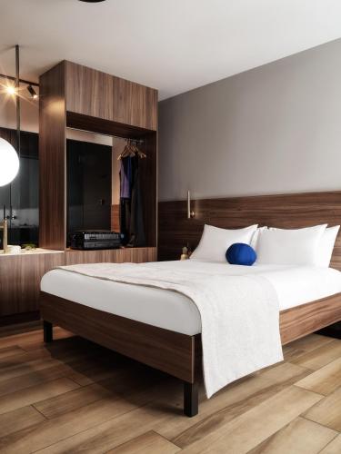 a bedroom with a large bed with a wooden headboard at The Newel Acropolis in Athens