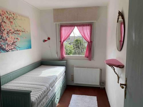 - une chambre avec un lit doté d'une fenêtre et de rideaux roses dans l'établissement Haus am See mit fantastischem Blick, à Rheinböllen