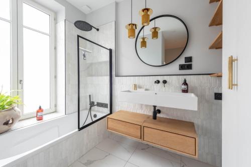 y baño con lavabo y espejo. en Le 360 - Appt vue panoramique sur Lyon, en Sainte-Foy-lès-Lyon