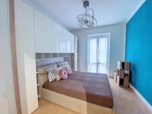 1 dormitorio con cama y lámpara de araña en Giuly House, en Arenzano
