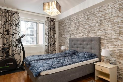 ラハティにあるKokonainen huoneisto 73m2 keskeisellä sijainnilla, ilmainen parkkipaikkaのベッドとレンガの壁がある寝室