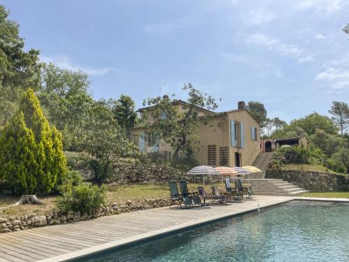 - une piscine avec des chaises et des parasols en face d'une maison dans l'établissement Mazet Pascaressa, à Tourrettes-sur-Loup
