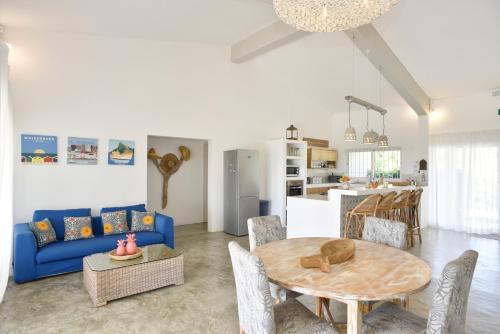 ein Wohnzimmer mit einem blauen Sofa und einem Tisch in der Unterkunft Rodrigues Holiday Family Villa Zourit in Rodrigues Island