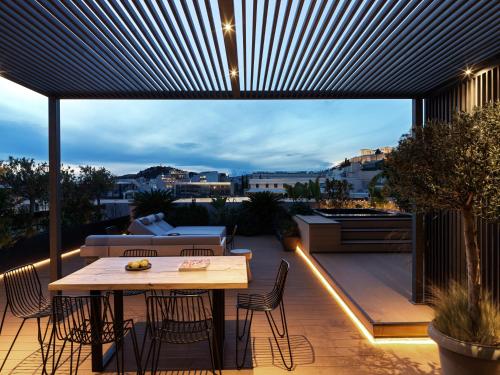 a patio with a table and chairs on a balcony at The Newel Acropolis in Athens