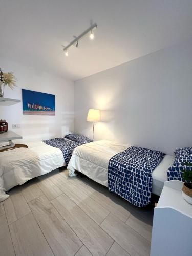 two beds in a room with white walls at Secret Surf House. Casa de playa. in Playa del Hombre