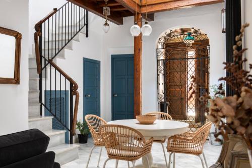 uma sala de jantar com uma mesa branca e cadeiras em Magno Apartments Vírgenes Luxury House em Sevilha
