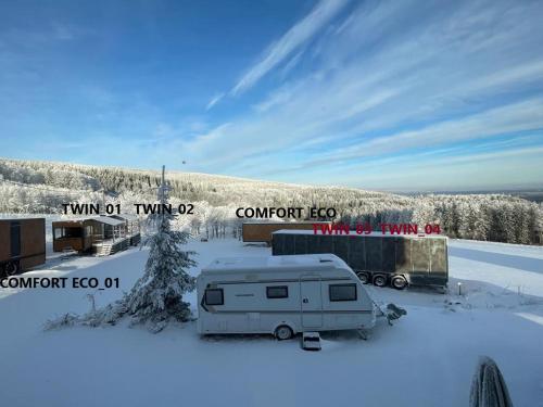 un camper e un rimorchio nella neve di Good Spot Zieleniec Twin Eco 02 a Duszniki Zdrój