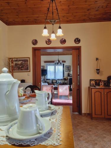 a dining room with white dishes on a table at Lake Stories in Koutsodímos