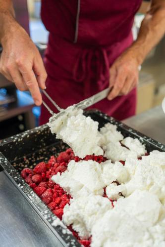 a person cutting a tray of berries with a knife at Wander- und Wellnesshotel Kanzler in Bad Mitterndorf