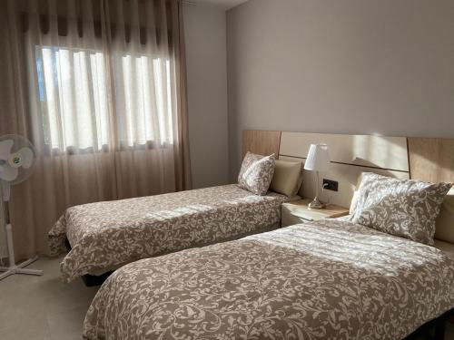 ラ・マタにあるOasis Beach El Raso Guardamarのベッド2台と窓が備わるホテルルームです。