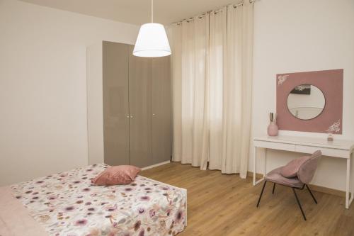 a bedroom with a bed and a desk and a mirror at La Casa dei Racconti in Castelraimondo