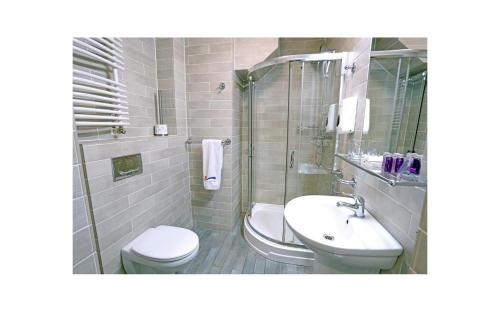 La salle de bains est pourvue de toilettes, d'un lavabo et d'une douche. dans l'établissement OSiR Polna, à Varsovie
