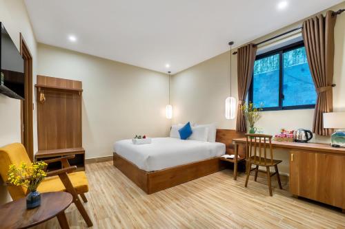 a hotel room with a bed and a desk at Nam An Mama Villa Hoi An in Hoi An