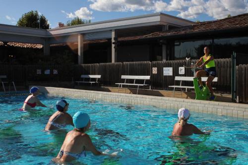 a group of people playing in a swimming pool at Estivo Premium Deluxe mobile homes on Camping Del Sole Village in Iseo