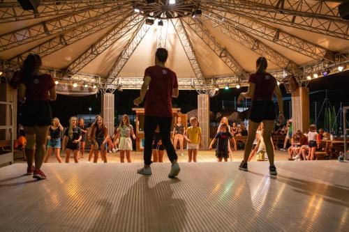 a group of people dancing on a dance floor in a tent at Estivo Premium Deluxe mobile homes on Camping Del Sole Village in Iseo