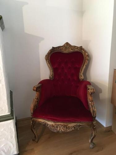 a red chair sitting in the corner of a room at Das Ferienhaus in Achenkirch in Achenkirch