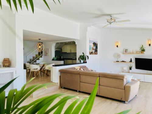 a living room and kitchen with a couch and a table at Villa with sea view and luxury heated pool in San Miguel de Abona