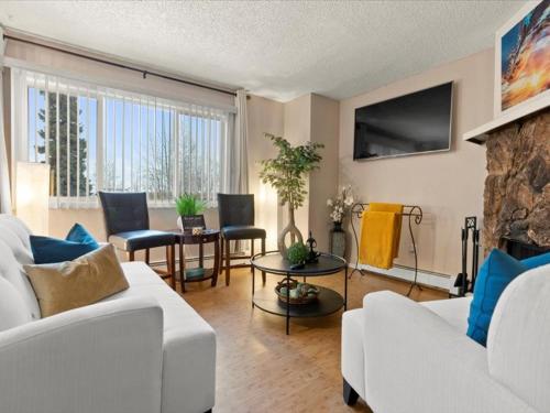 a living room with a white couch and a fireplace at Lovely 3-bedroom rental unit with free parking! in Anchorage