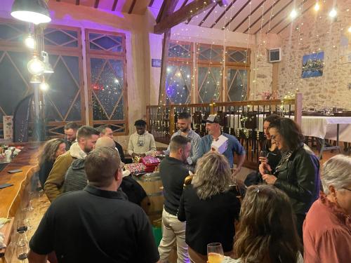 Un groupe de personnes se tenant autour d'un bar dans une pièce dans l'établissement Domaine La Tour, à Loubens