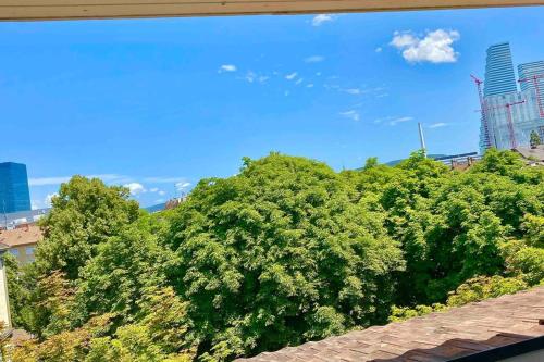 a view from a window of trees and buildings at Ganze Wohnung mit Balkon,schöne Aussicht,Küche,Bad,Wifi in Basel