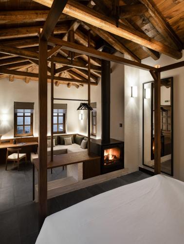 a room with a fireplace and a couch and a bed at Unedo All Seasons Boutique Hotel in Palaios Panteleimon
