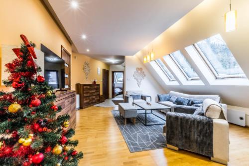 a christmas tree in the living room of a house at Przy Nosalu 42 Apartments SPA&SKI Jacuzzi Sauna Free in Zakopane