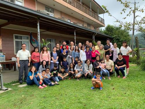 a group of people posing for a picture in front of a house at 星光山悦景觀民宿 in Heping