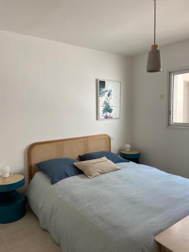 une chambre avec un grand lit avec des oreillers bleus dans l'établissement T3 pour 6 dans résidence neuve avec piscine, à Calvi