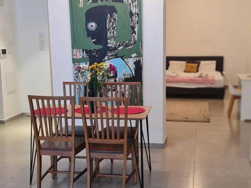 un tavolo e sedie con un vaso di fiori sopra di Amazing Garden apartment a Tel Aviv