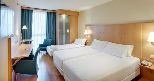 a hotel room with two beds and a desk at Sercotel Porta Barcelona in Sant Just Desvern