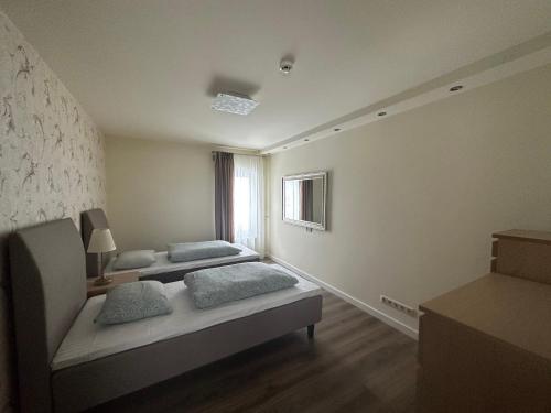 een kamer met 2 bedden en een raam bij Apartamentai in Marijampolė