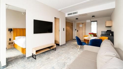 a living room with a couch and a bed and a table at Złoty Horyzont, Sun & Snow in Szklarska Poręba