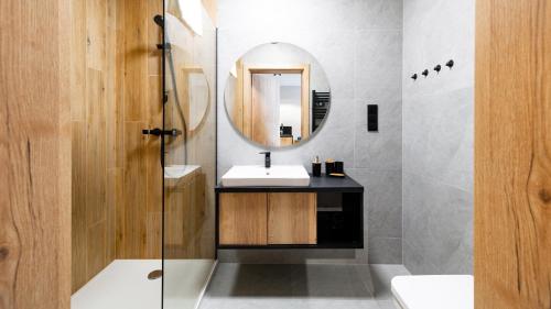 a bathroom with a sink and a mirror at Apartamenty Sun & Snow Złoty Horyzont in Szklarska Poręba